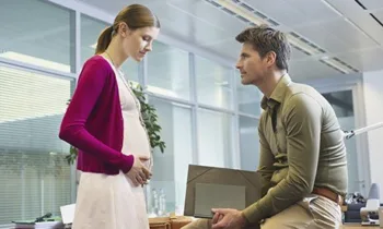 Pregnant woman and man in the office